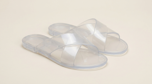 Sandália Melissa transparente unissex com tiras cruzadas em fundo neutro