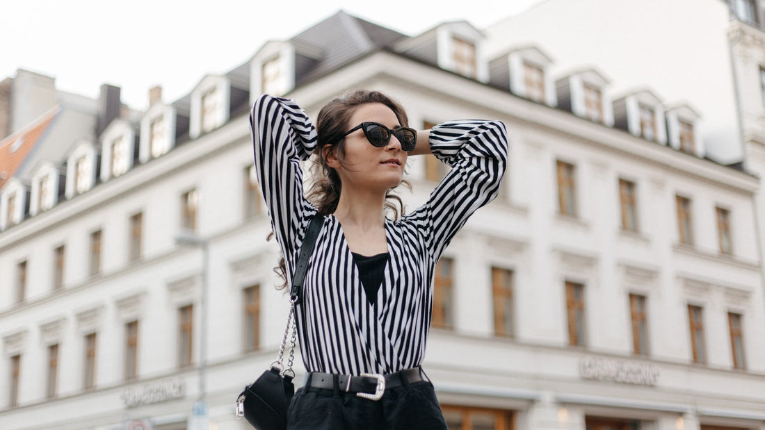 Mulher em look street style com camisa de listras preto e branco
