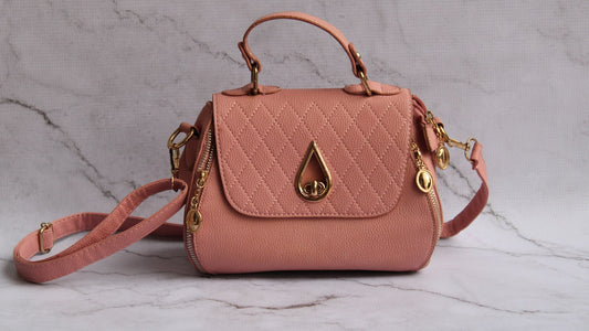 Bolsa transversal rosa feminina com alça longa sobre superfície de mármore